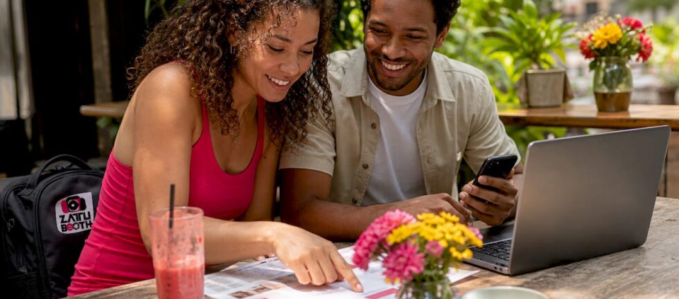 Couple reviewing wedding photo booth options at kitchen table