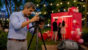 Photographer setting up studio DSLR booth in event hall