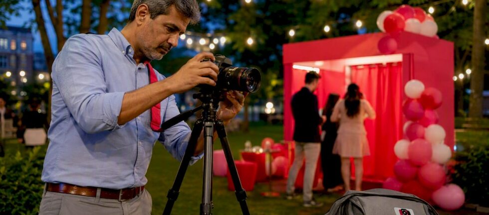 Photographer setting up studio DSLR booth in event hall