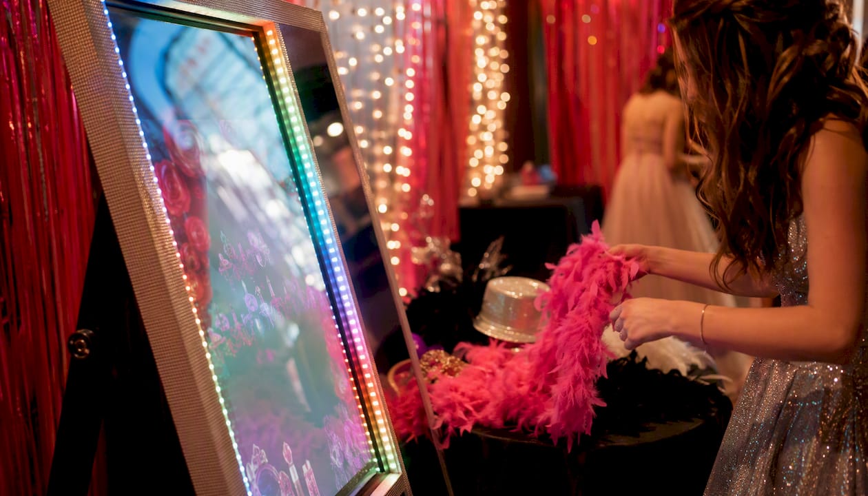Hands adjusting props at glam mirror photo booth